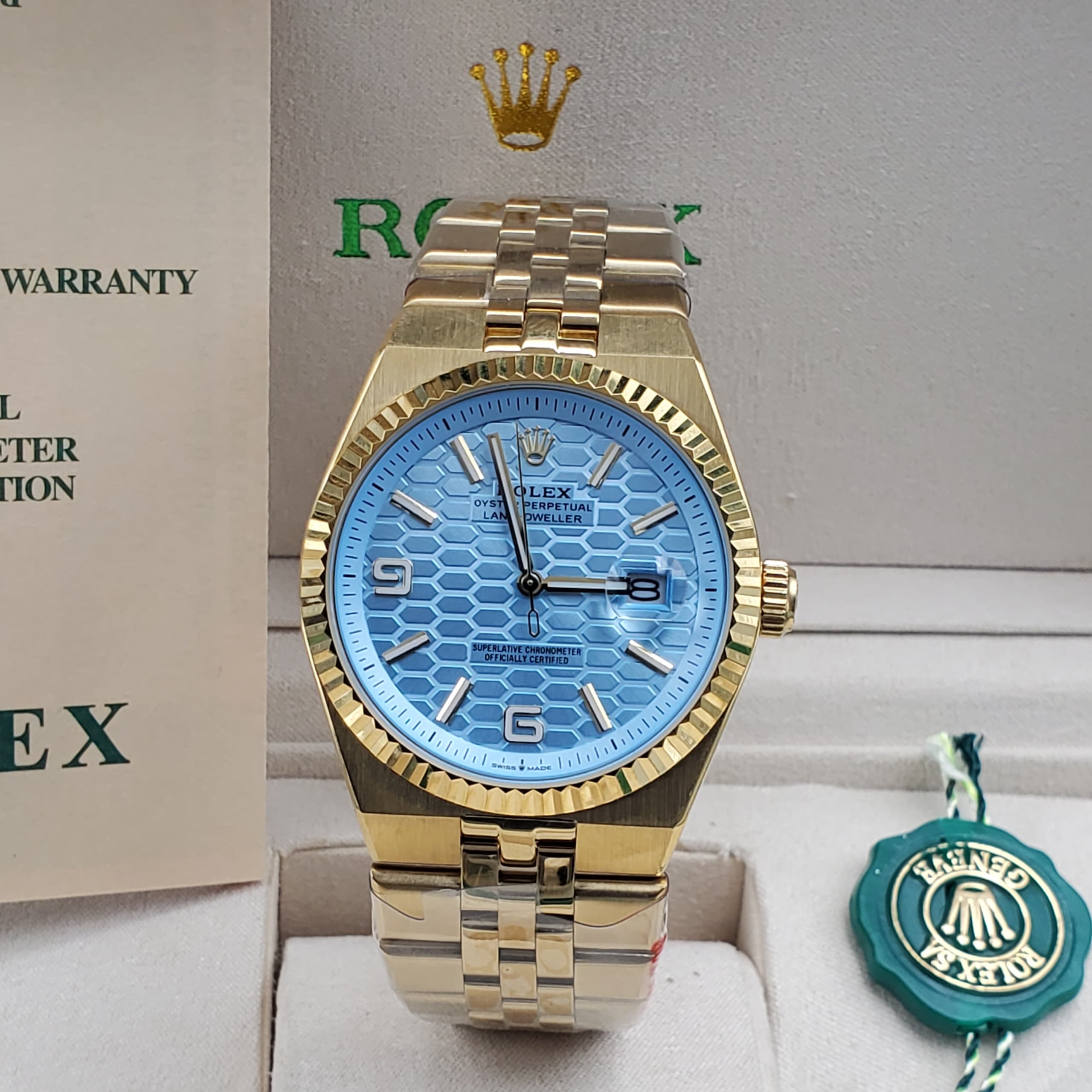 Rolex Oyster Perpetual Land-Dweller in gold with a blue honeycomb dial and Jubilee bracelet.